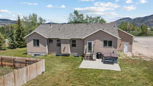 Rear exterior of a stucco residence featuring a shingle roof
