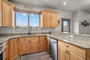 Kitchen featuring light wood cabinetry and granite-style countertops