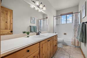 Bathroom featuring a wood-finish vanity with an integrated sink and light-colored countertop