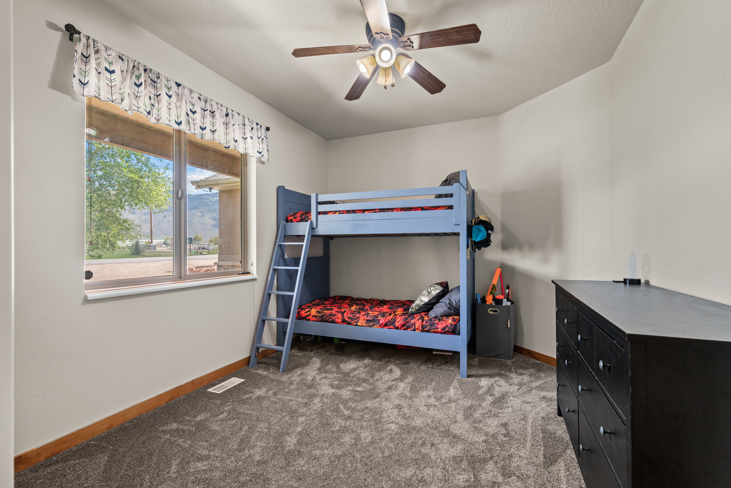 Room featuring neutral painted walls, gray textured carpet, and a wood-finish baseboard