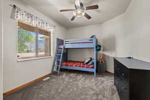 Room featuring neutral painted walls, gray textured carpet, and a wood-finish baseboard