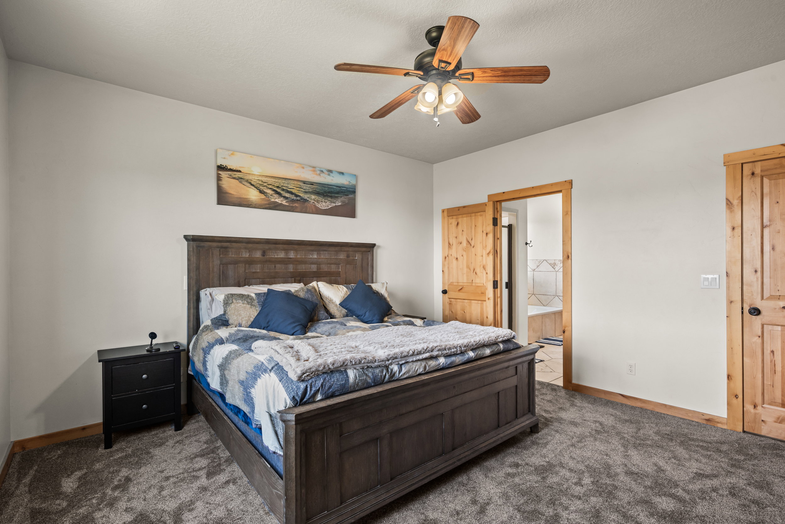 Bedroom featuring plush carpeting, light-toned walls, and wood-trim accents