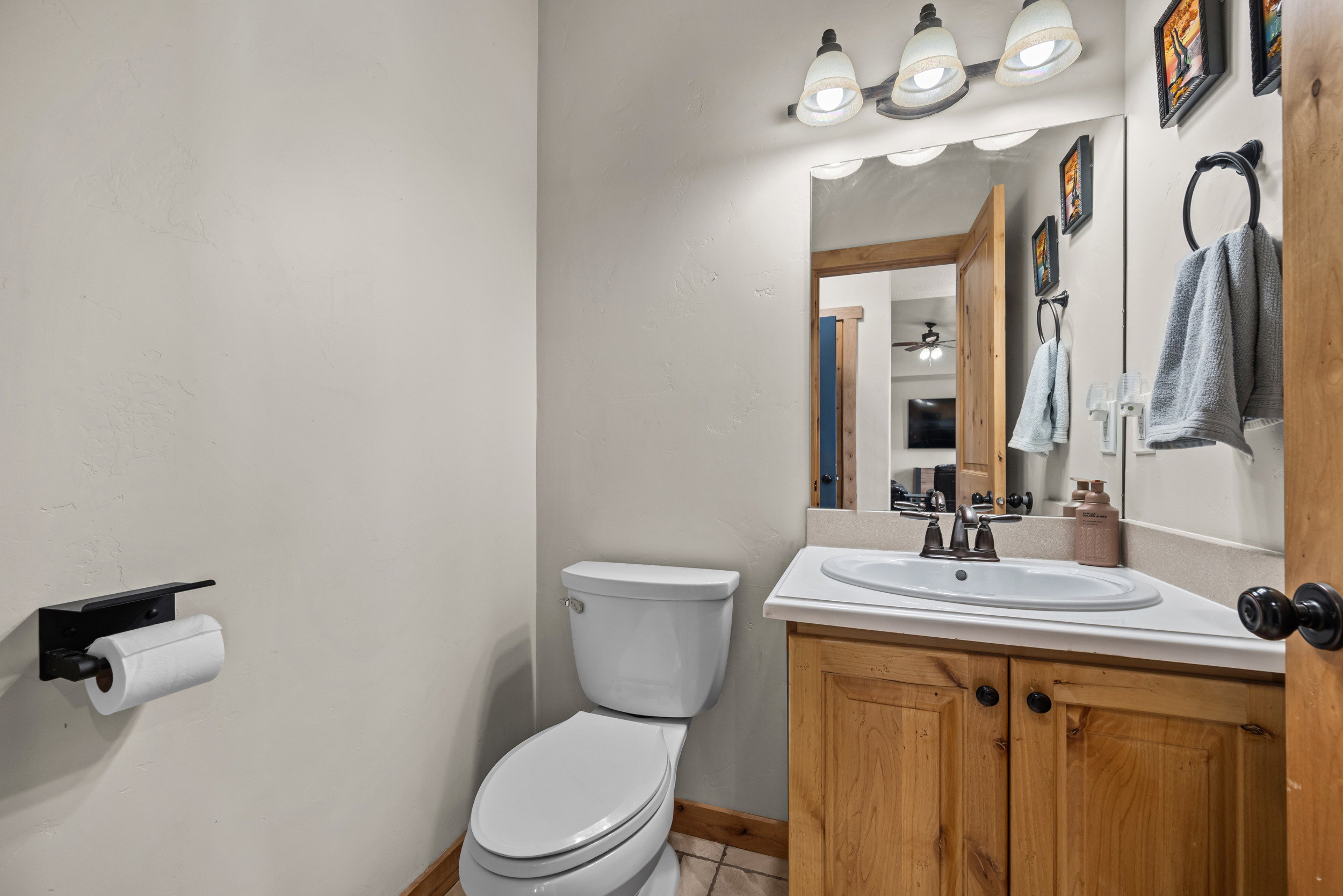 Bathroom vanity featuring a light-colored countertop, integrated sink, and wood-finish cabinetry