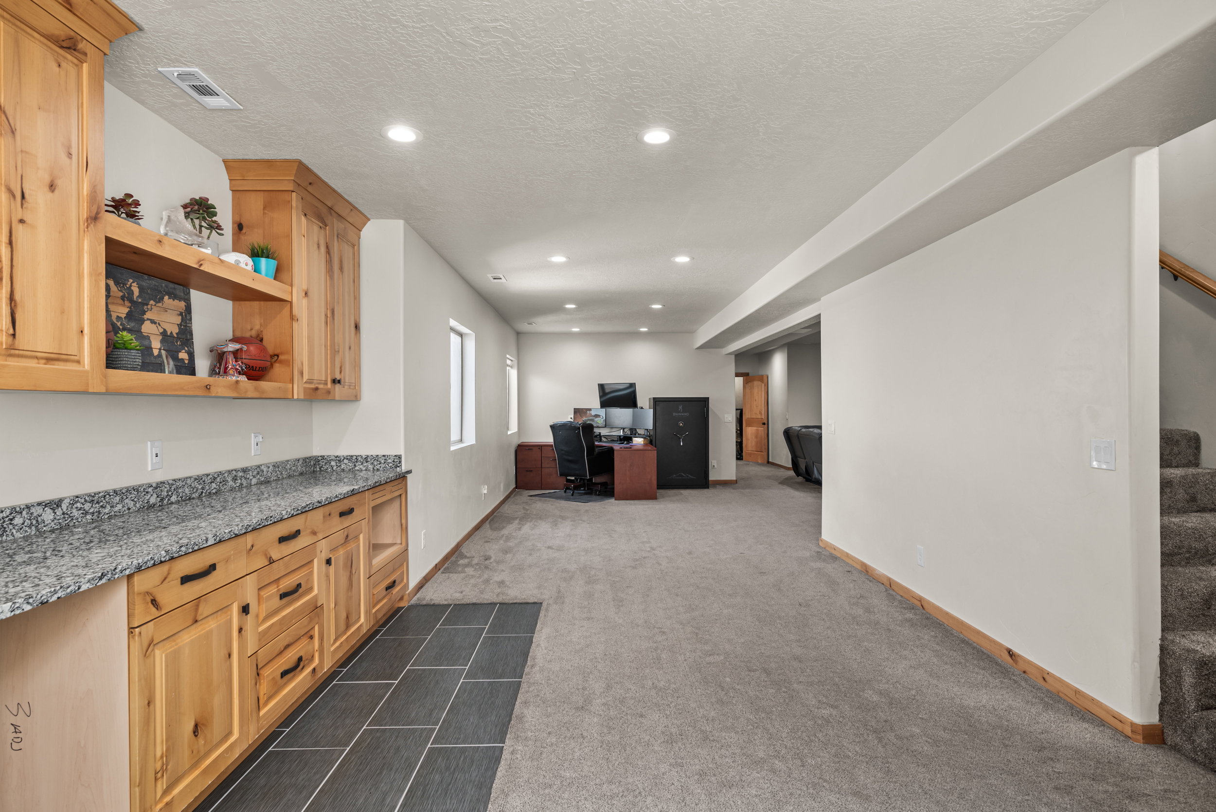 Built-in cabinetry with a granite-style countertop and open shelving