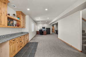 Built-in cabinetry with a granite-style countertop and open shelving
