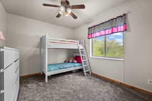 Bedroom featuring gray carpet flooring, light neutral wall paint, and a window offering natural light