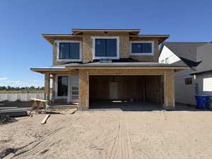 Two-story residential structure under construction, featuring an attached garage