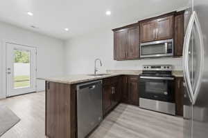 Modern kitchen featuring wood-finish cabinetry, stainless steel appliances, and granite countertops