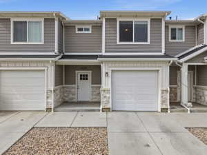 Contemporary townhome exterior featuring horizontal siding and stone veneer accents