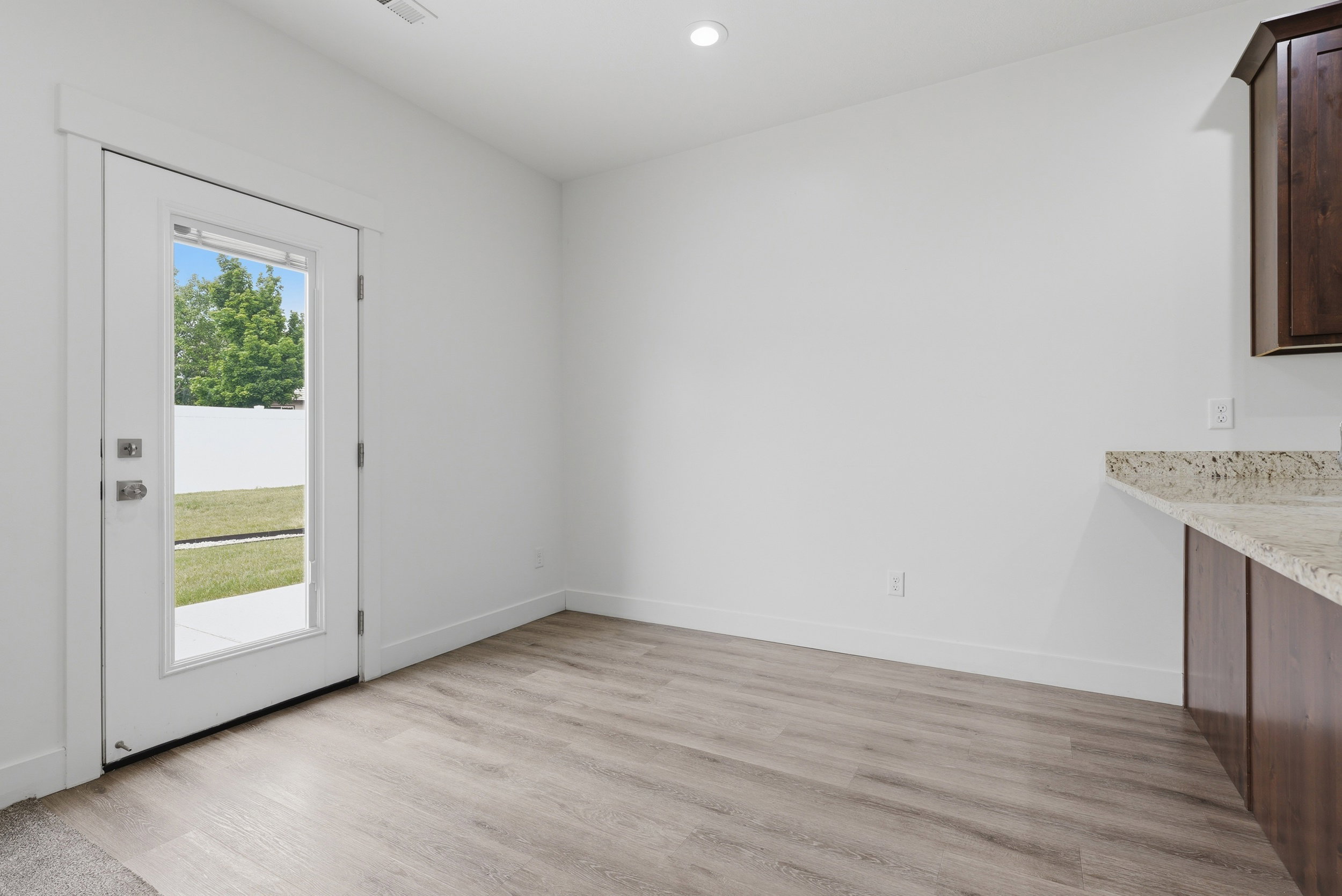 Light wood-finish flooring with a white trim baseboard