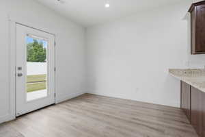 Light wood-finish flooring with a white trim baseboard