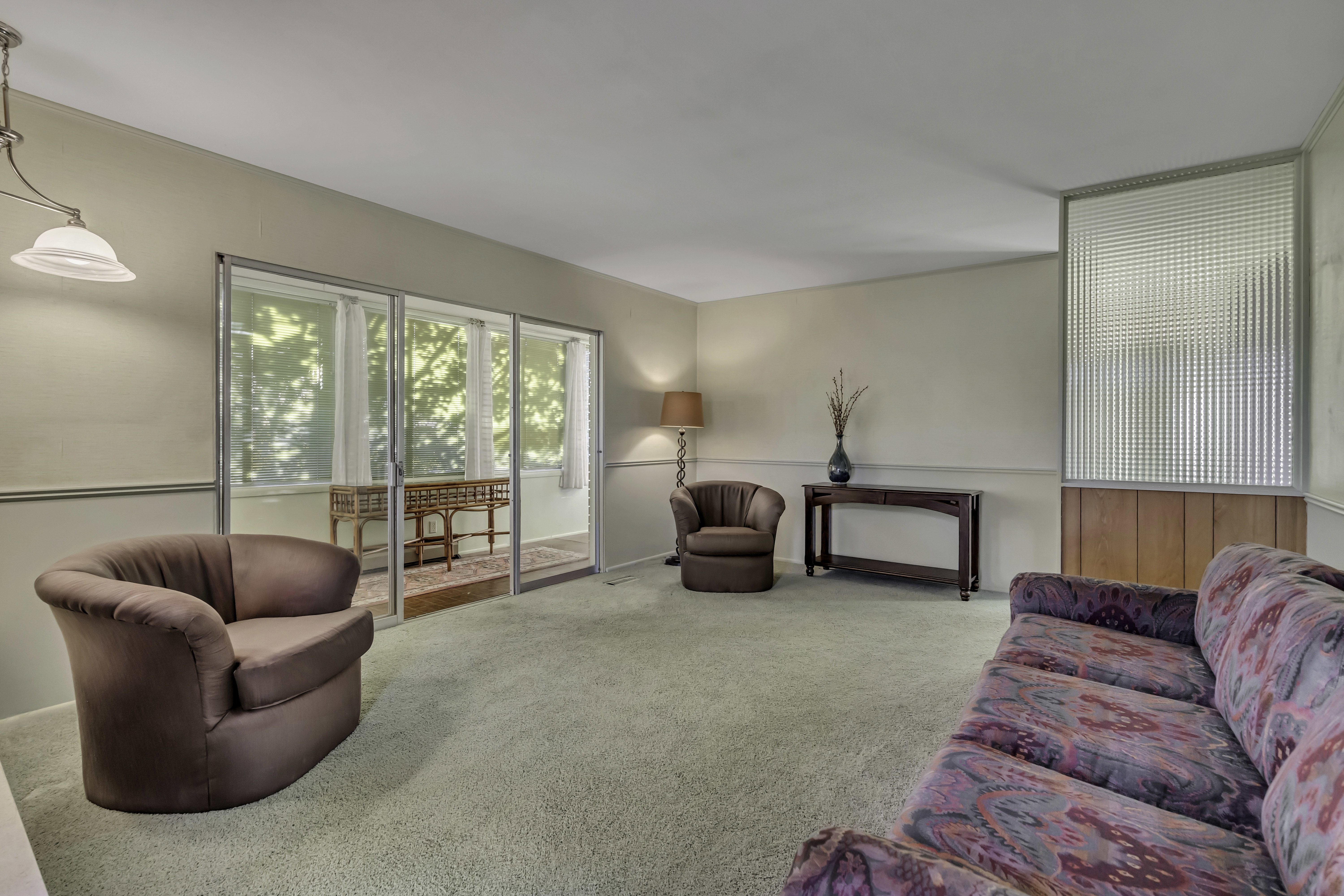 Living area featuring light-toned walls with chair rail molding and light-colored carpeting