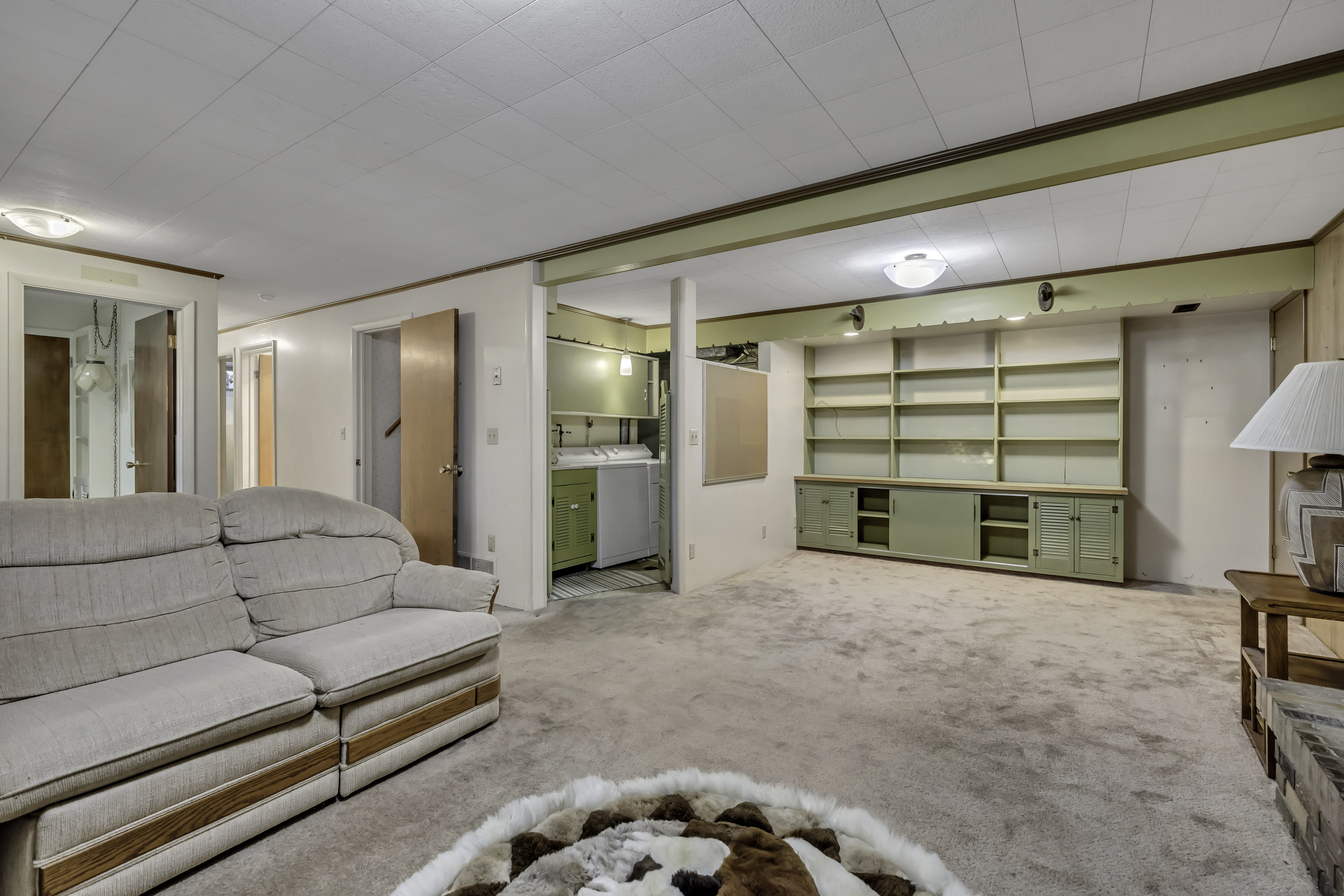 Versatile lower-level room featuring carpet flooring and a suspended ceiling