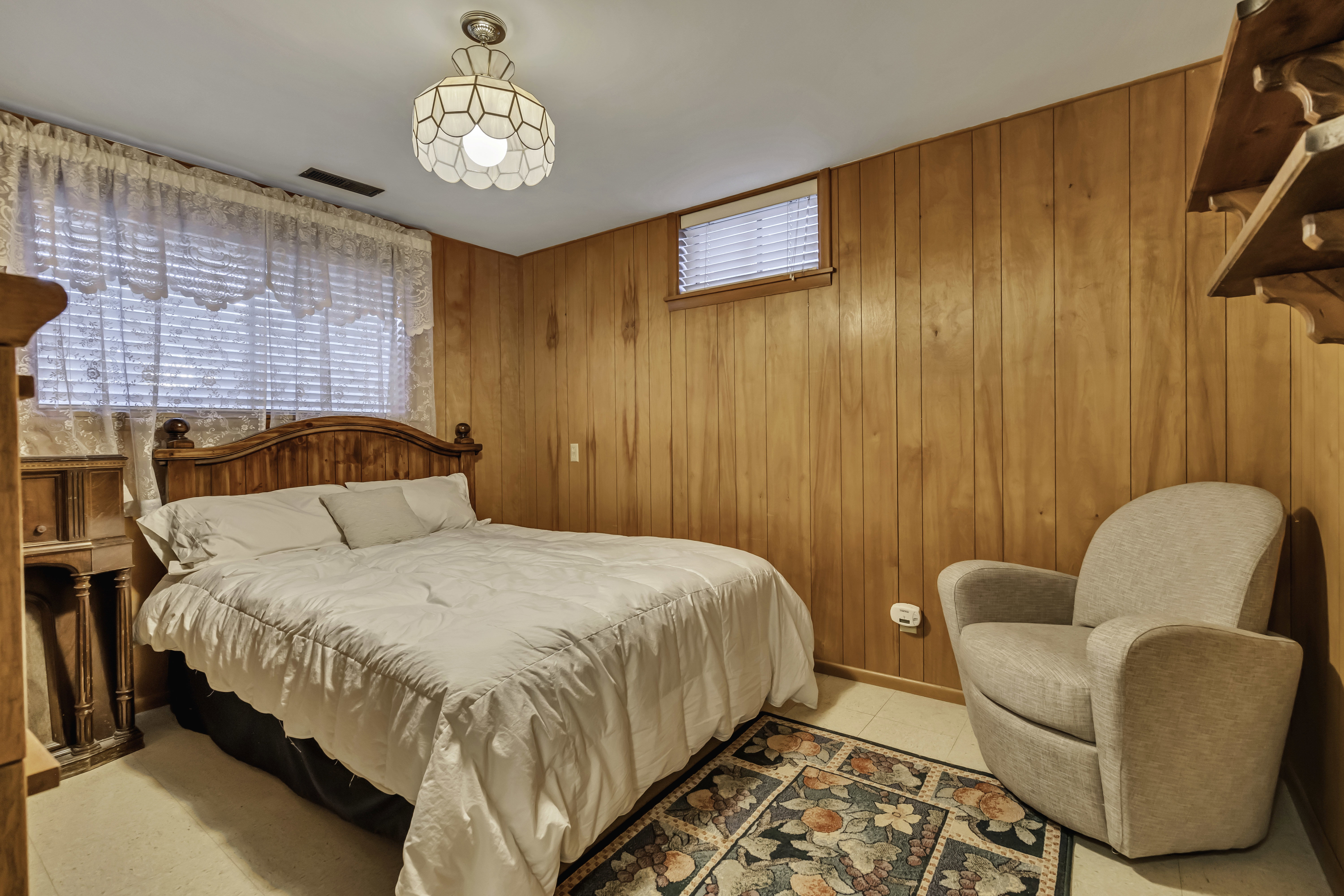 Room featuring wood paneling, a recessed window with blinds, and light-toned flooring