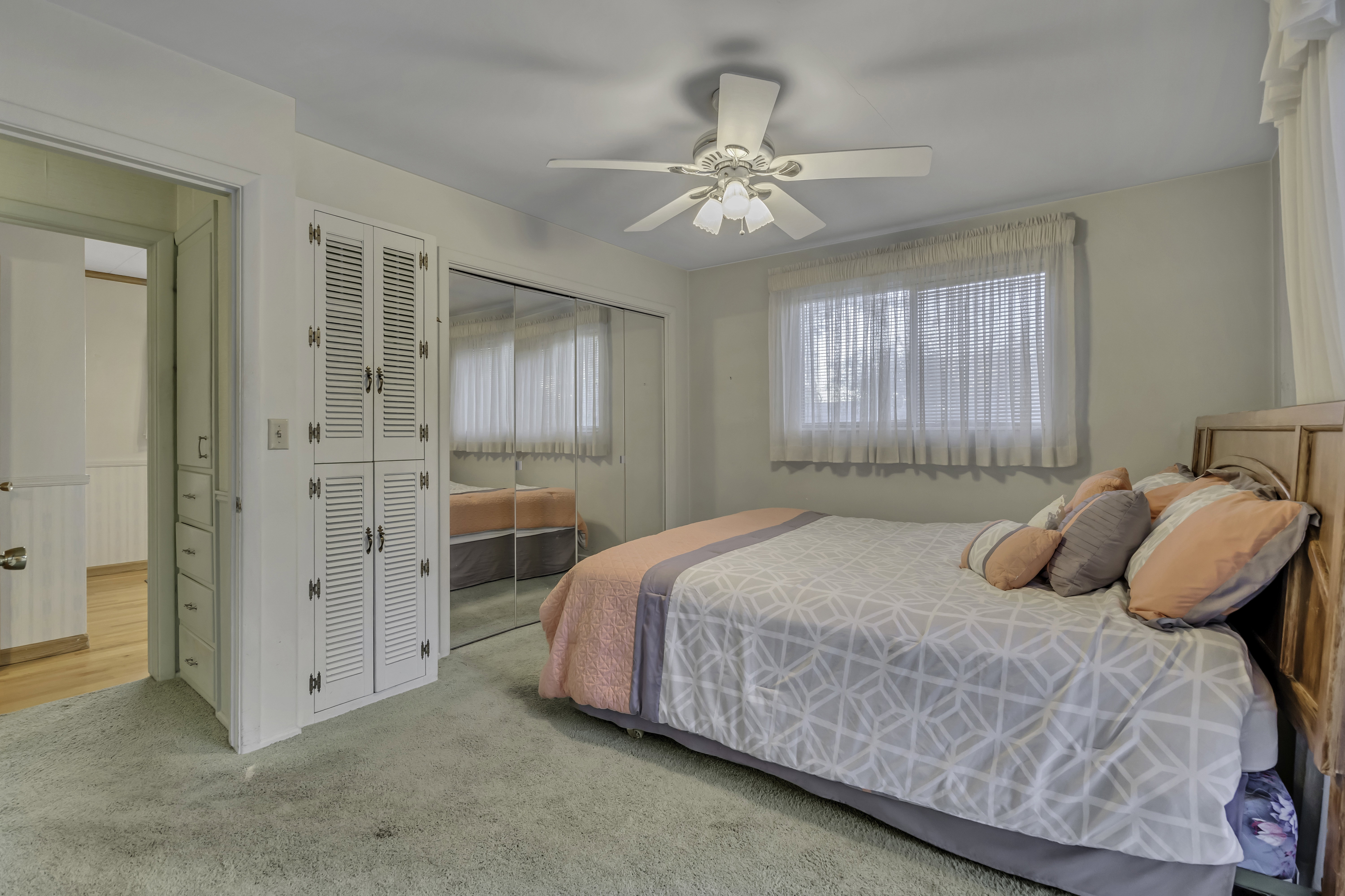 Plush green carpeting with a ceiling fan overhead