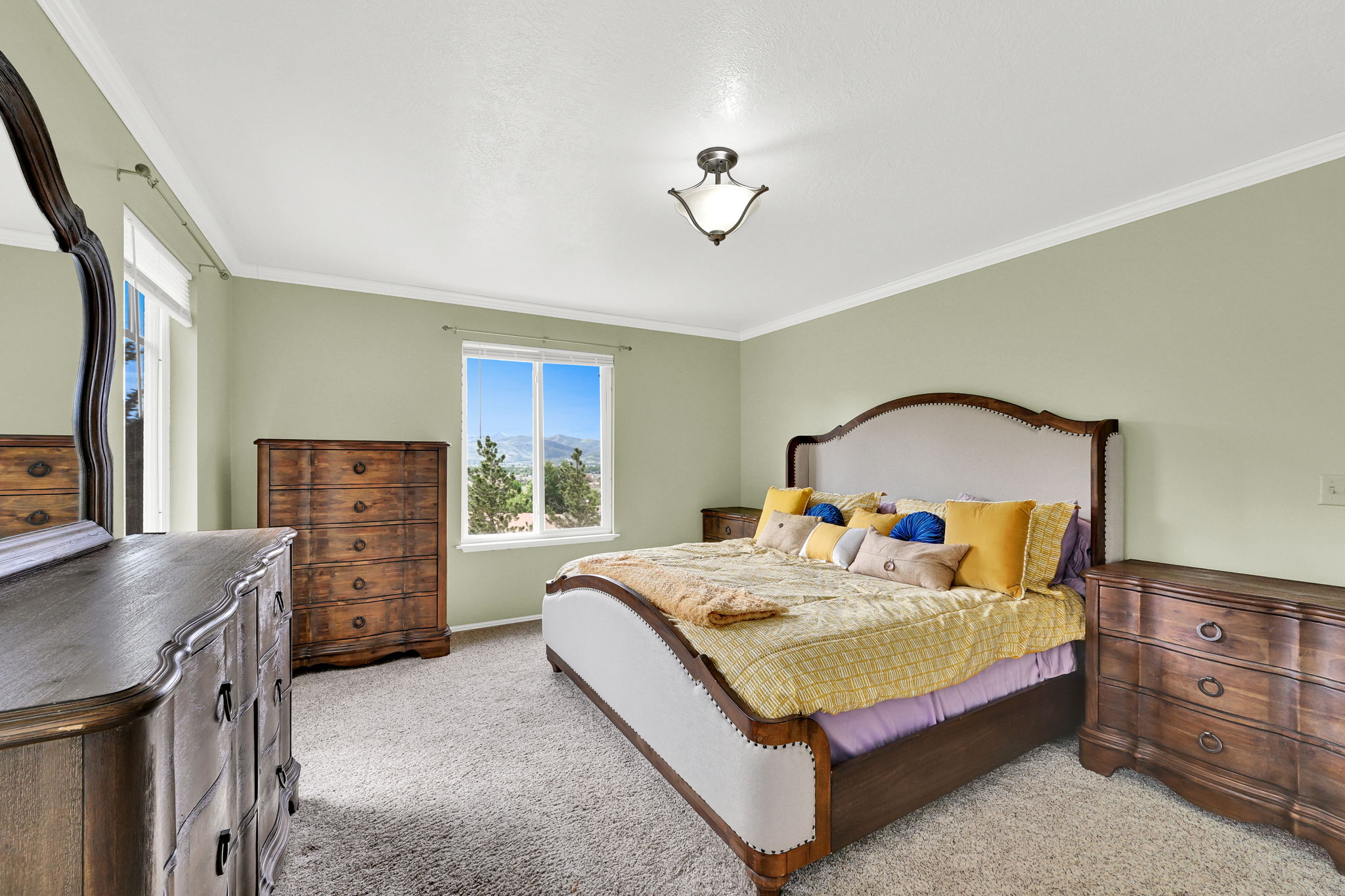 Spacious room featuring light green walls, white crown molding, and plush carpeting