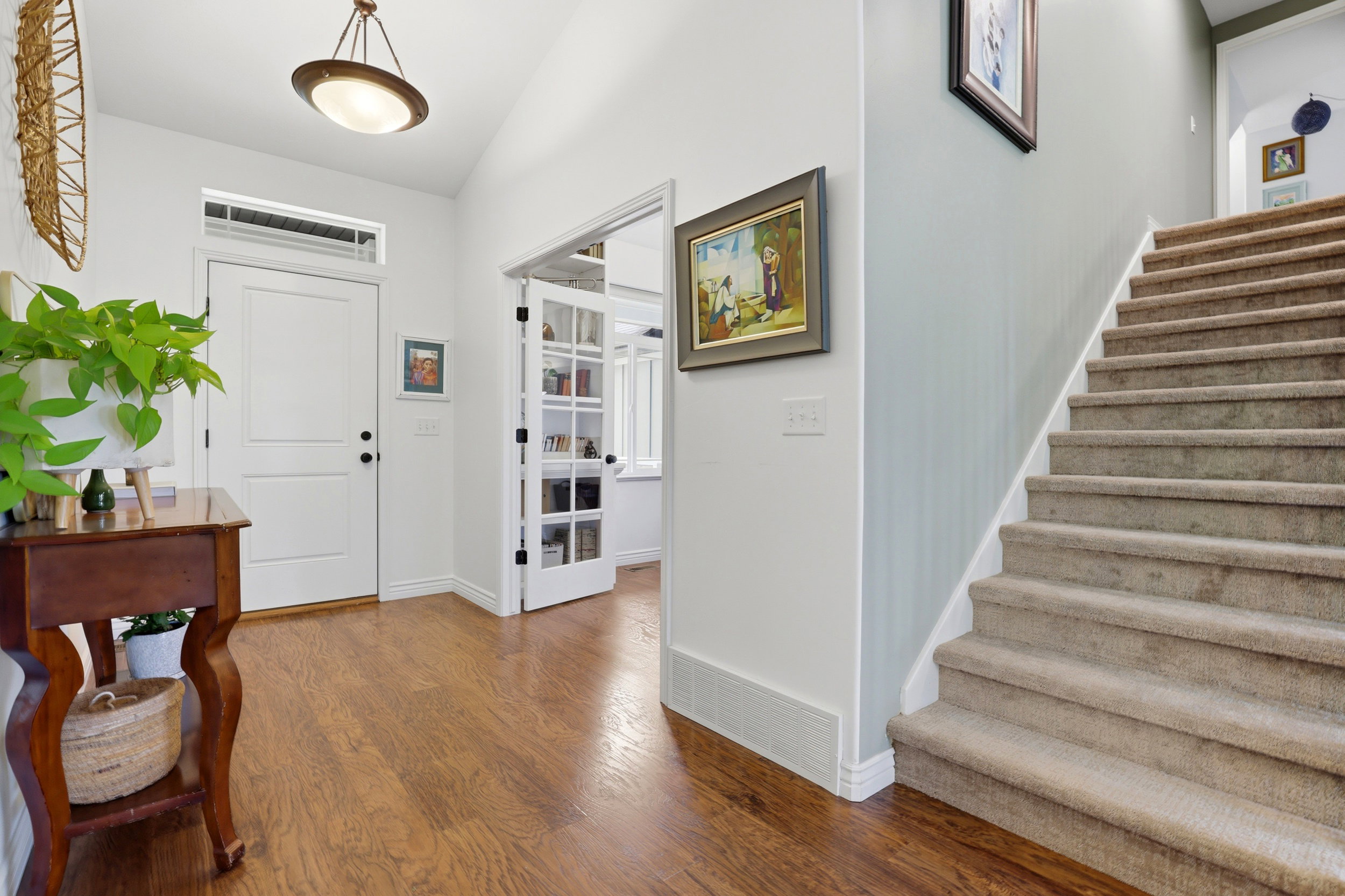 Entryway featuring wood-finish flooring, a white two-panel door with transom window, and a ceiling-mounted light fixture