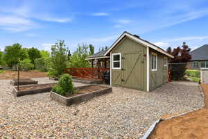Olive green storage shed with white trim, featuring double barn doors and multiple windows