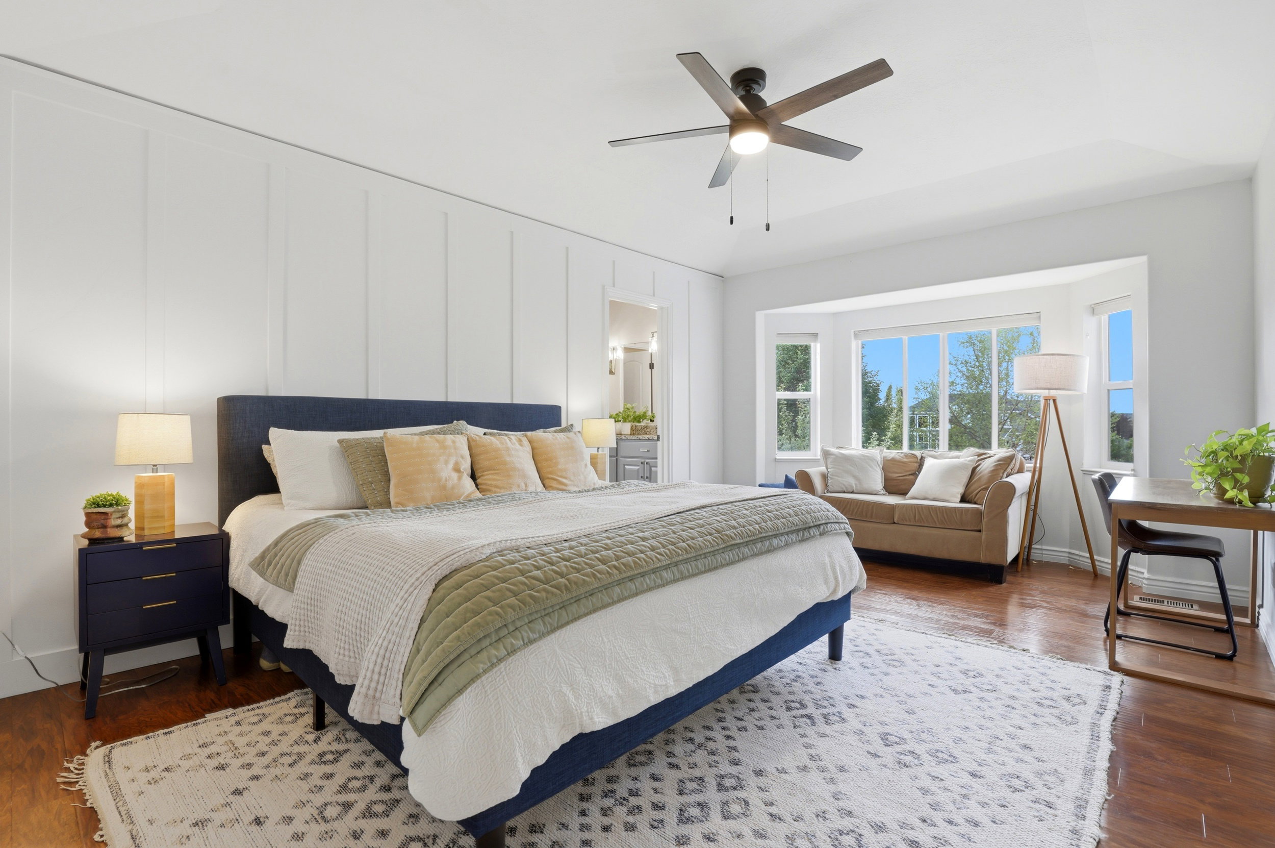 Spacious room featuring rich wood-finish flooring and a contemporary ceiling fan