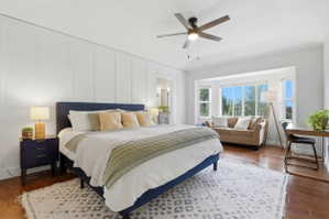 Spacious room featuring rich wood-finish flooring and a contemporary ceiling fan