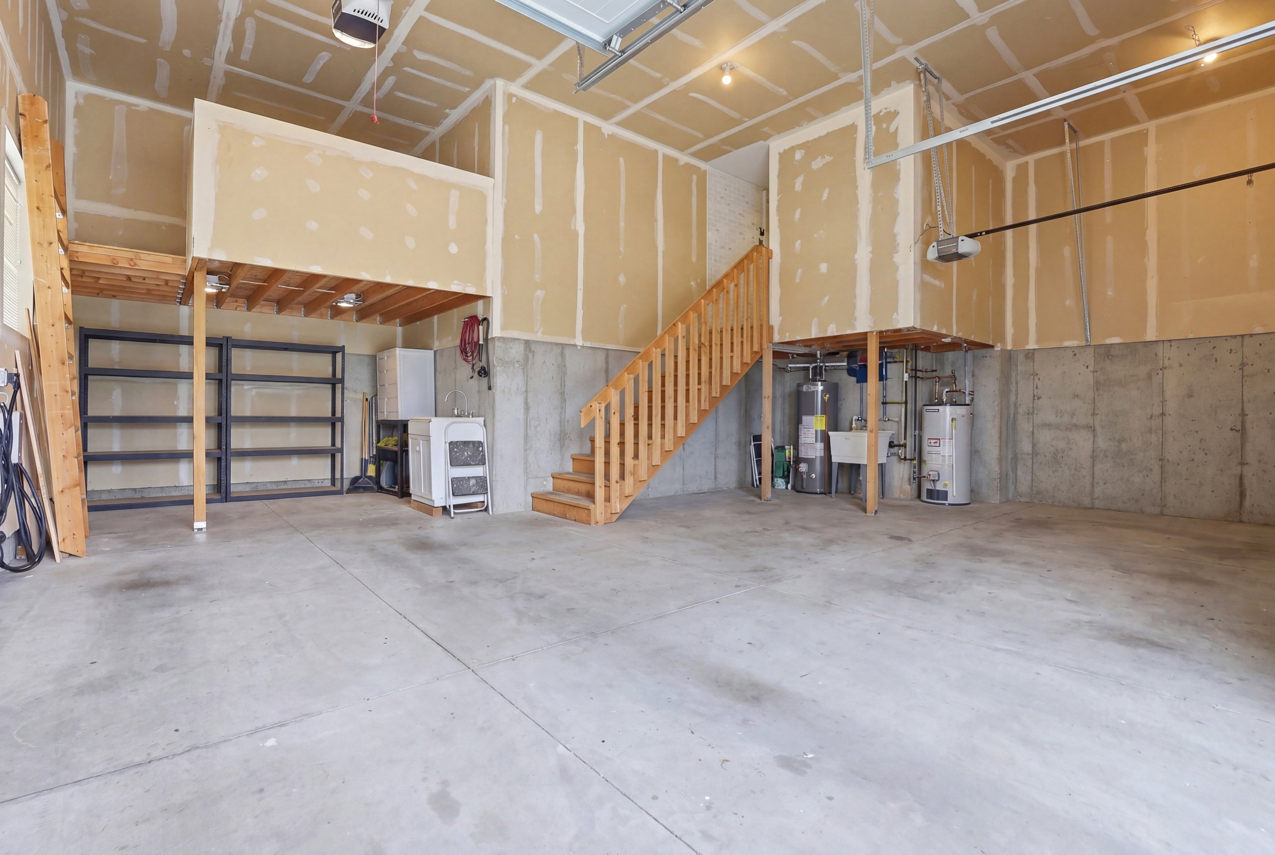 Spacious garage with concrete flooring and exposed ceiling joists