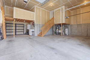 Spacious garage with concrete flooring and exposed ceiling joists