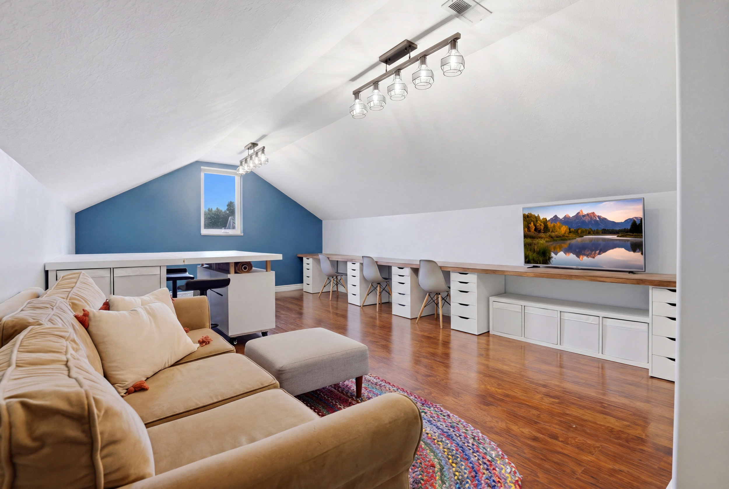 Spacious attic conversion featuring vaulted ceilings and recessed lighting