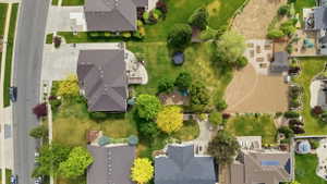 Expansive property featuring a large, manicured lawn, established trees, and a spacious rear patio
