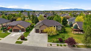 Expansive residential lot featuring a two-story home with a two-car garage, mature landscaping, and an extended concrete driveway
