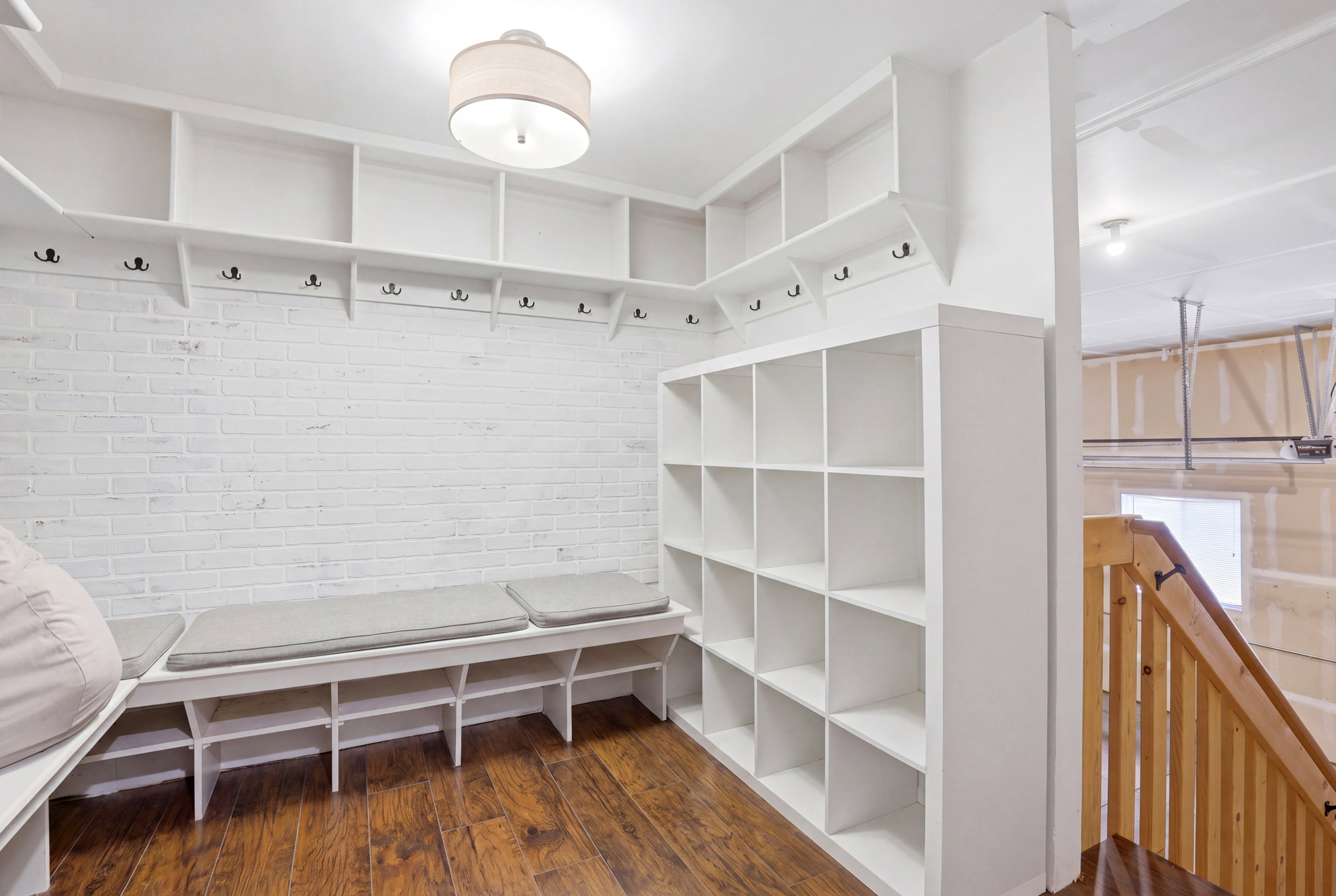 Built-in mudroom features custom shelving, storage cubbies, bench seating, and coat hooks