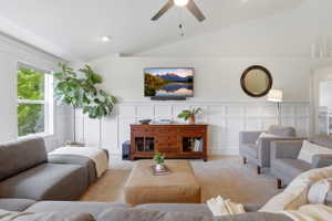 Vaulted ceilings and recessed lighting illuminate this carpeted living space
