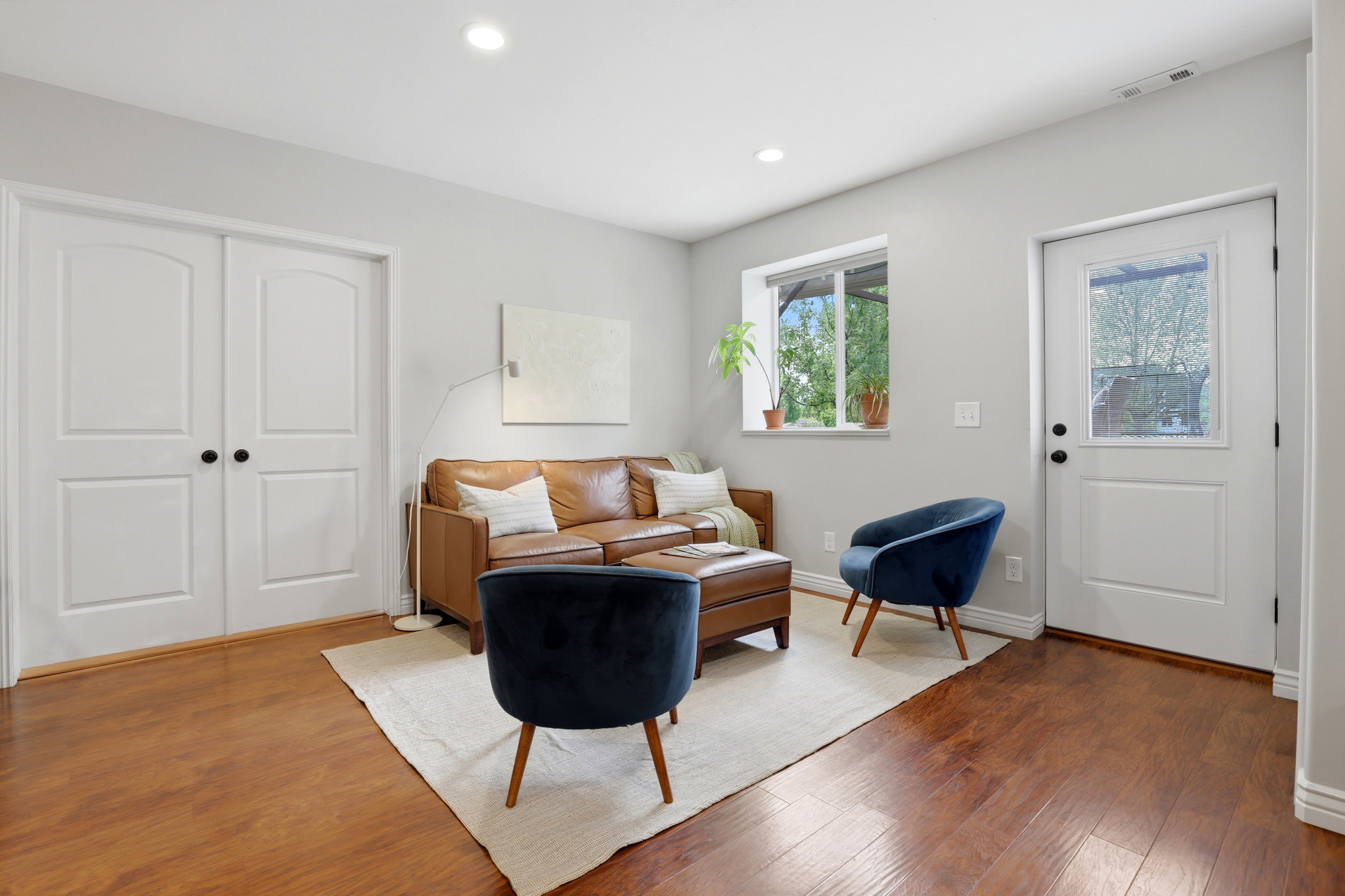 Warm wood-finish flooring complements the neutral wall color of this adaptable space