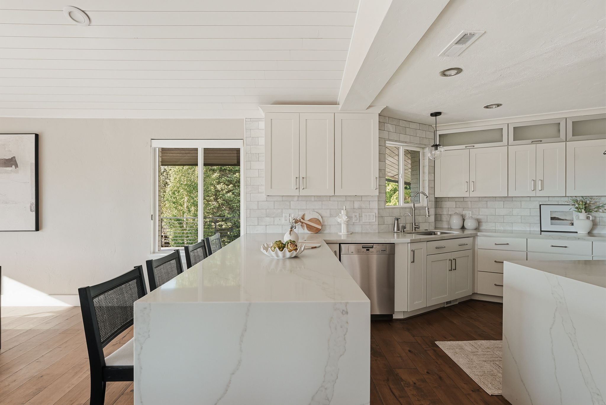 Expansive kitchen island featuring a waterfall edge and stone-finish countertop