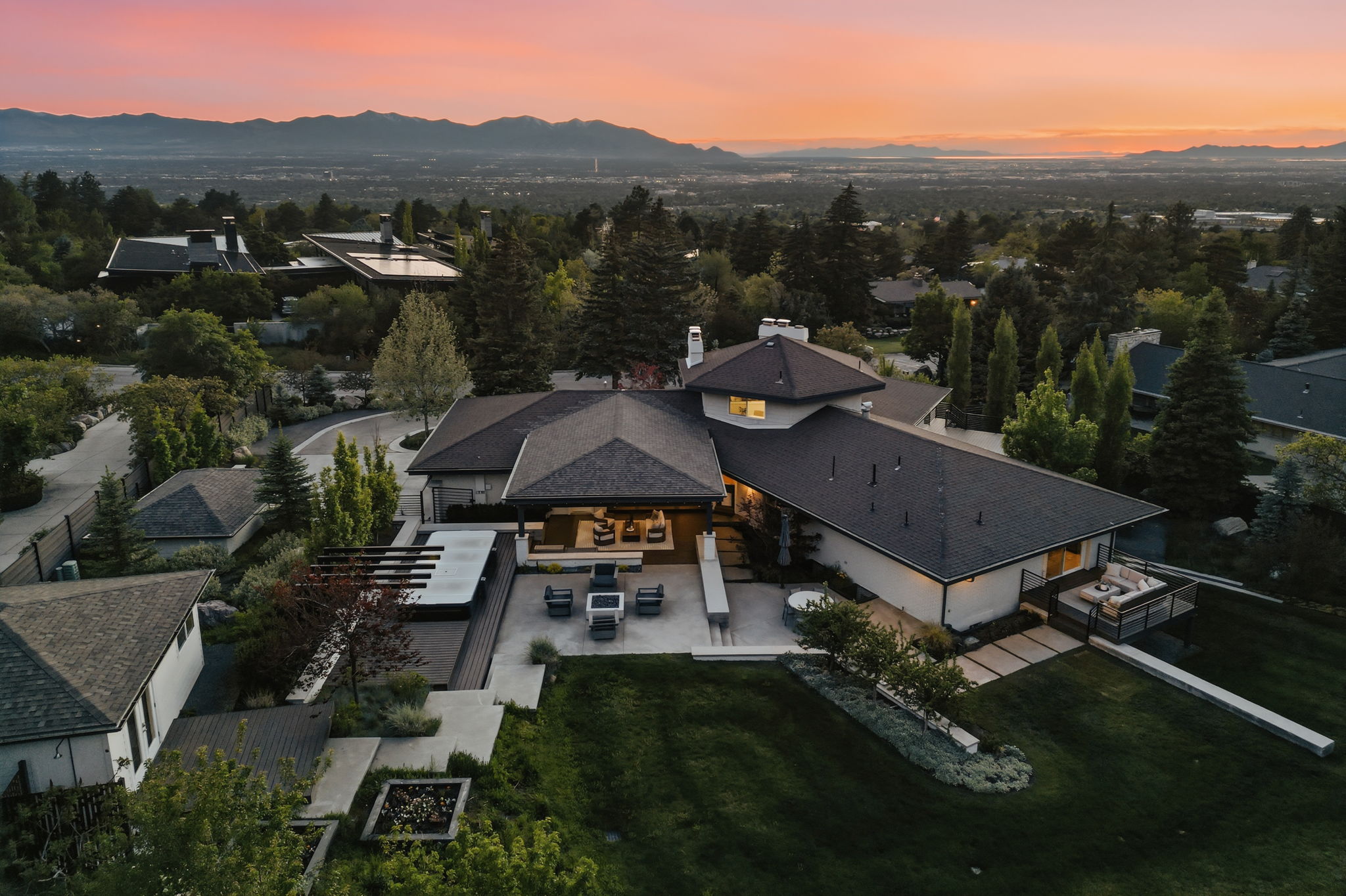 Expansive property featuring a multi-level architectural design, a large private patio with a pergola, and a spacious lawn area