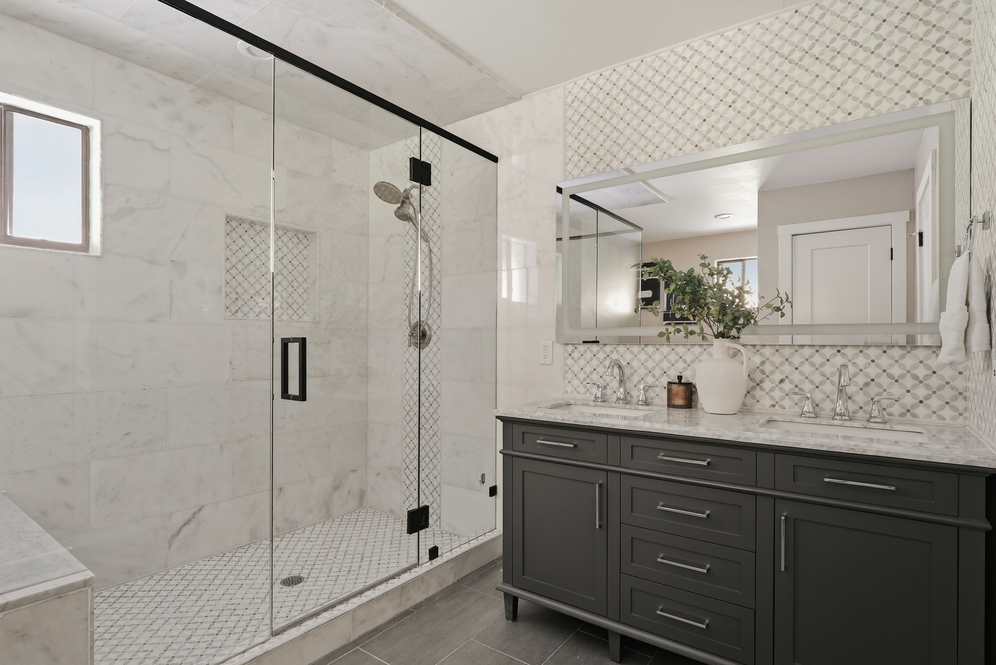 Frameless glass shower enclosure with matte black hardware