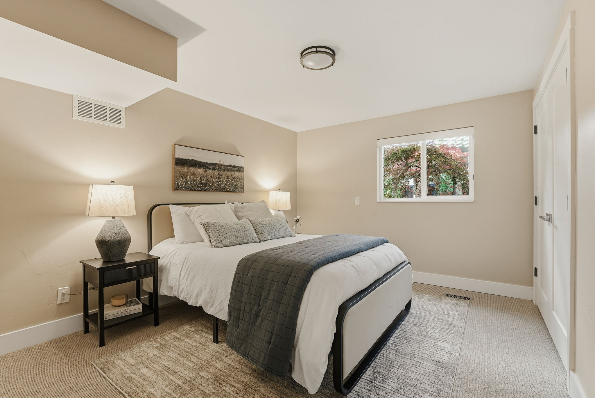 Carpeted room featuring a single window, white trim, and a white interior door