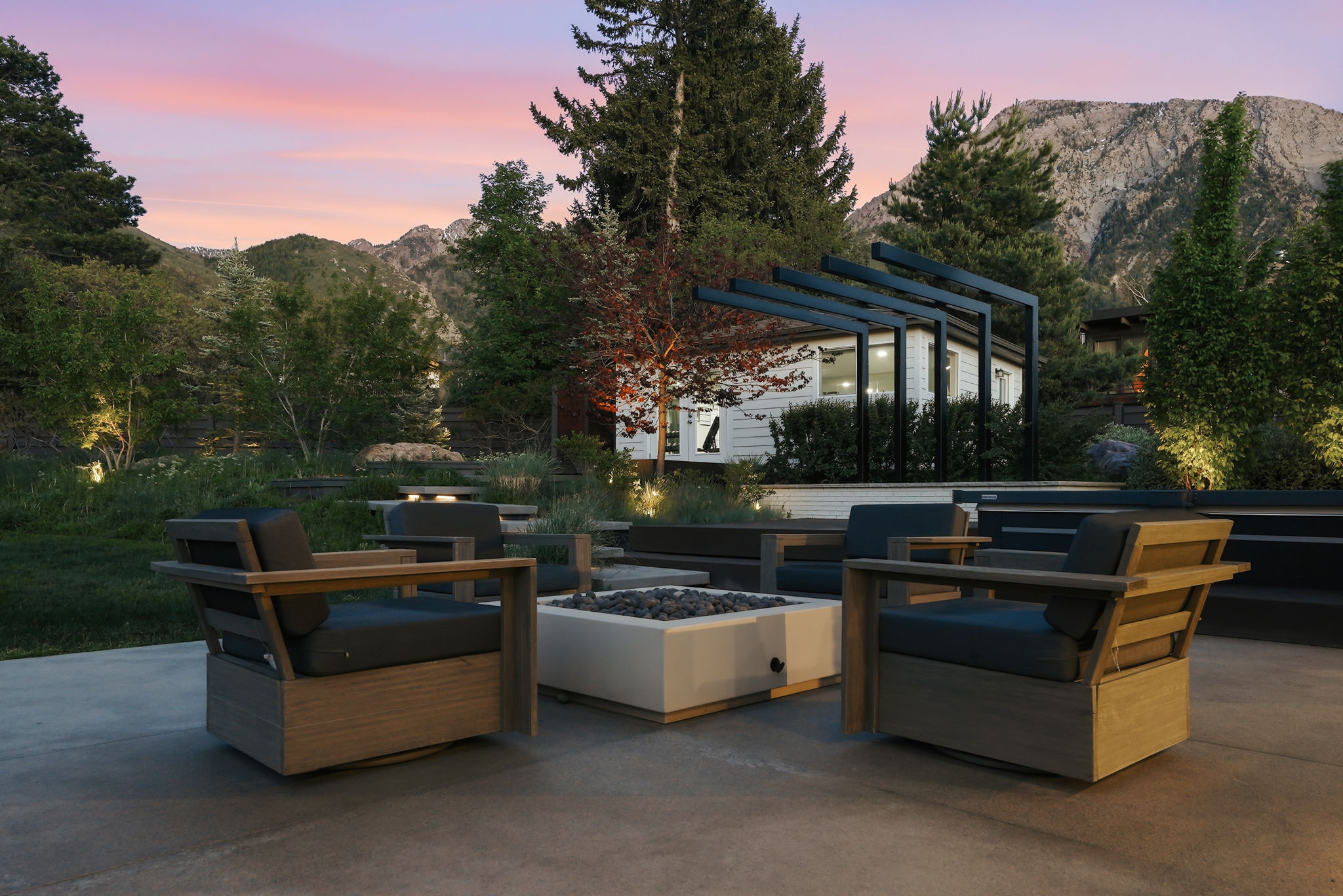 Outdoor patio featuring a built-in fire pit, concrete flooring, and surrounding mountainous landscape