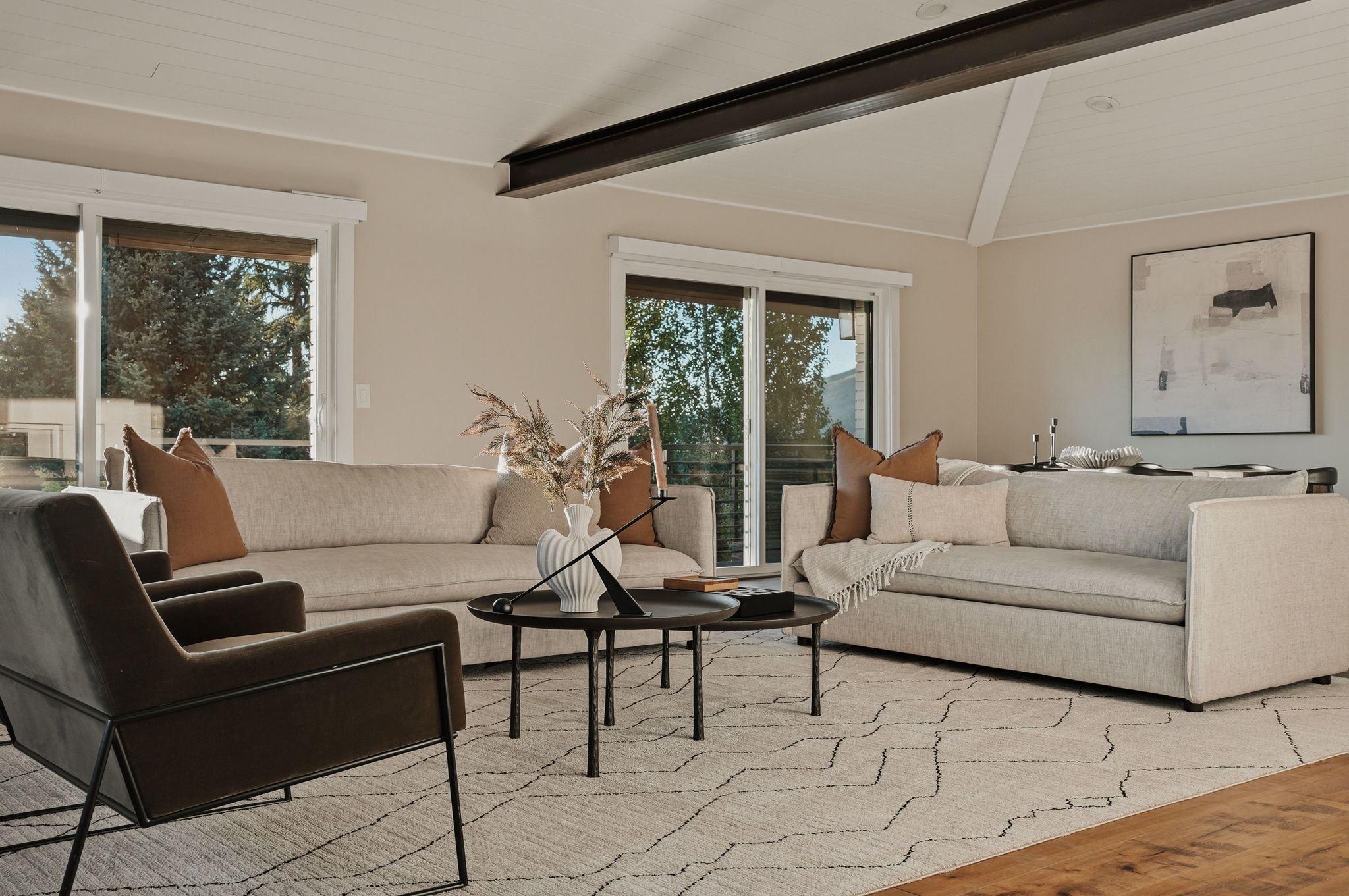 Living area featuring a vaulted ceiling with exposed beams, recessed lighting, and expansive sliding glass doors