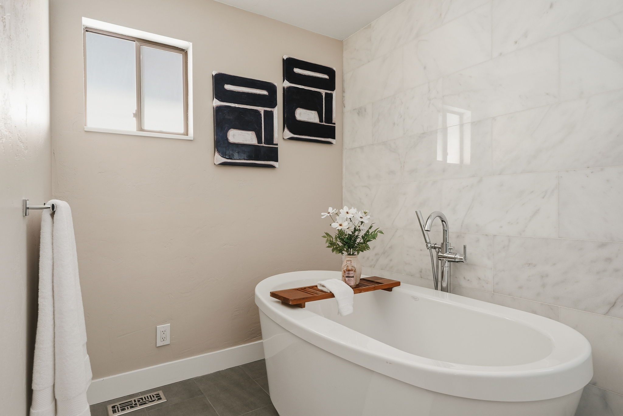 Freestanding soaking tub with polished chrome floor-mounted filler
