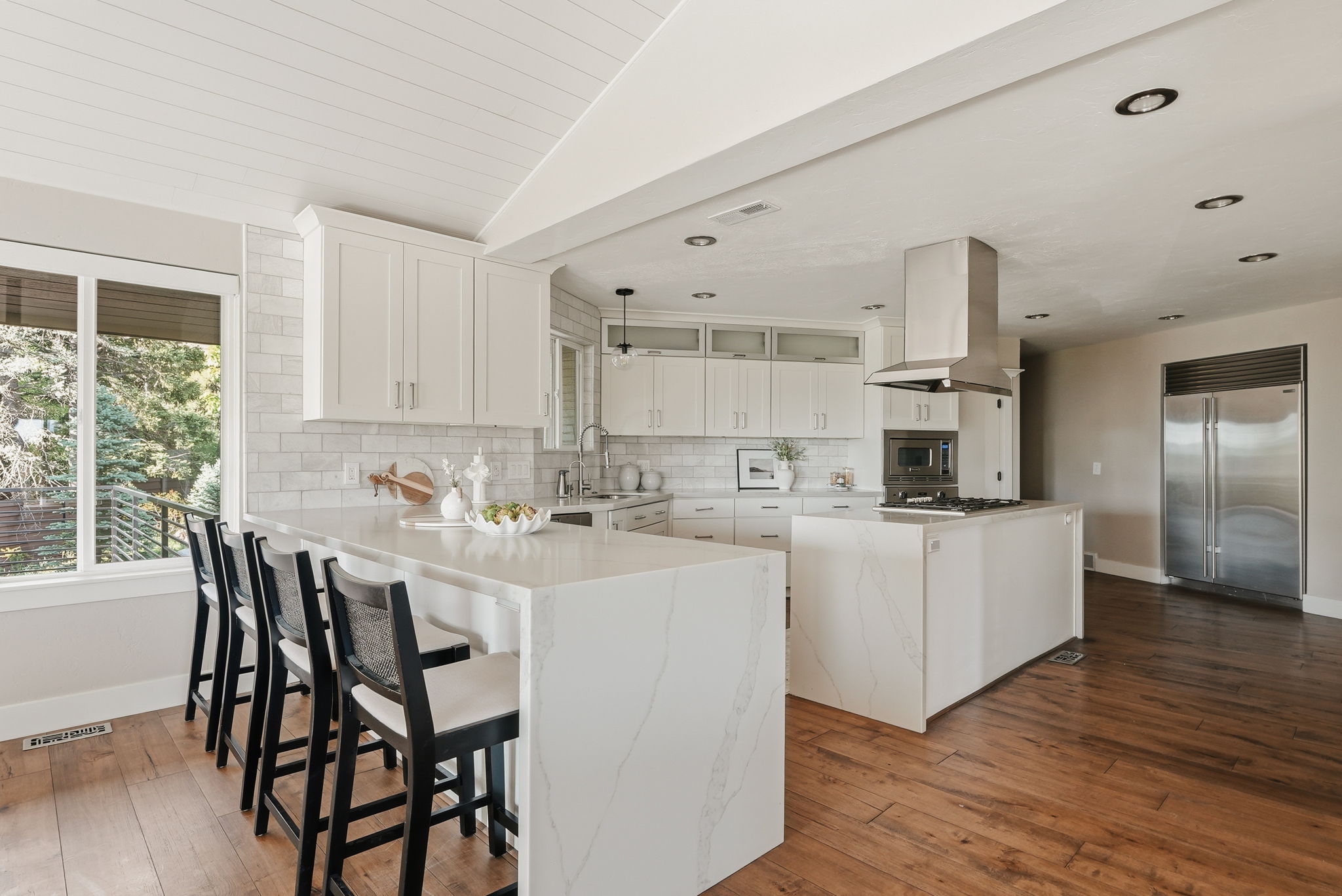 Modern kitchen featuring white cabinetry, subway tile backsplash, and wood-finish flooring