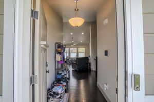 Entryway featuring dark wood-finish flooring, a contemporary ceiling light fixture, recessed lighting, and light-toned wall paint