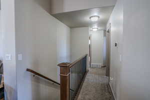 Hallway featuring neutral-toned walls and carpet flooring
