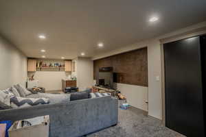 Spacious room featuring recessed lighting, a textured accent wall, and built-in cabinetry with open shelving