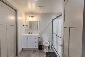 Bathroom featuring a white vanity with integrated sink, rectangular mirror, and a three-light fixture