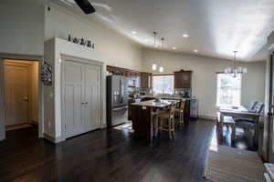 Open-concept living area featuring dark wood-finish flooring, vaulted ceilings, and recessed lighting