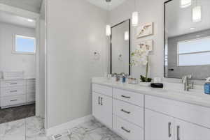 Double vanity with undermount sinks, white cabinetry, and quartz countertops