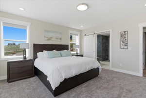 Spacious bedroom featuring light-toned walls, recessed lighting, and a contemporary ceiling fixture