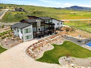 Contemporary hillside residence featuring stacked stone accents and expansive window placements