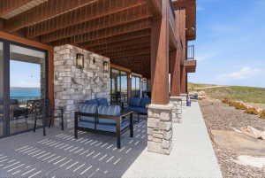 Covered patio with stone accent wall and exterior lighting
