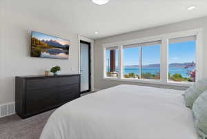 Large windows providing water and mountain scenery, recessed lighting, and light grey walls